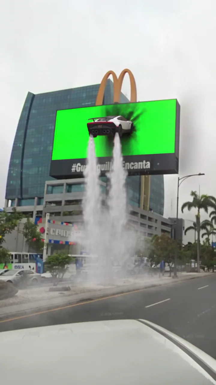 La toma original del choque con el panel verde detrás del carro y el humo.